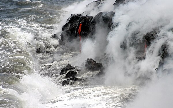 Pāhoehoe (smooth lava) spills into the ocean, forming new rock