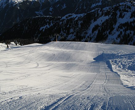 A groomed alpine skiing piste or trail