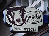 Praha - Dejvice, Kyjevská 3, bar Pivní Jistota, poutač pivovaru Krkonošský medvěd