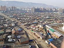 Частный сектор с юртами на фоне высотных новостроек Улан-Батора.