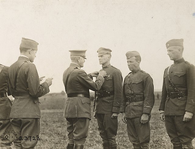 General John J. Pershing decorates Brigadier General Douglas MacArthur (third from left) with the Distinguished Service Cross in late 1918. Major Gene