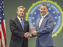 FBI Director Christopher Wray presents Dr. Adrian Bird, Chair of Interfaith Partners of South Carolina, with the Director's Community Leadership Award, 2019. Columbia-dcla-2018-interfaith-partners-of-south-carolina-050319.jpg