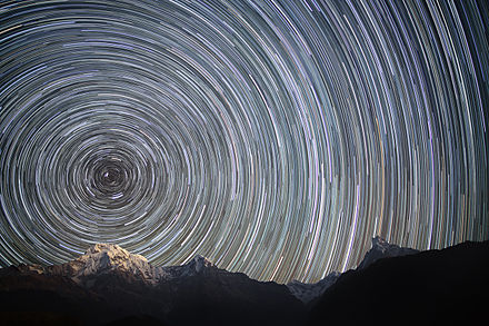 צילום בחשיפה ארוכה של שמי הלילה הצפוניים מעל הרי ההימלאיה הנפאליים מציג את הנתיבים הנראים של הכוכבים בזמן סיבוב כדור הארץ.