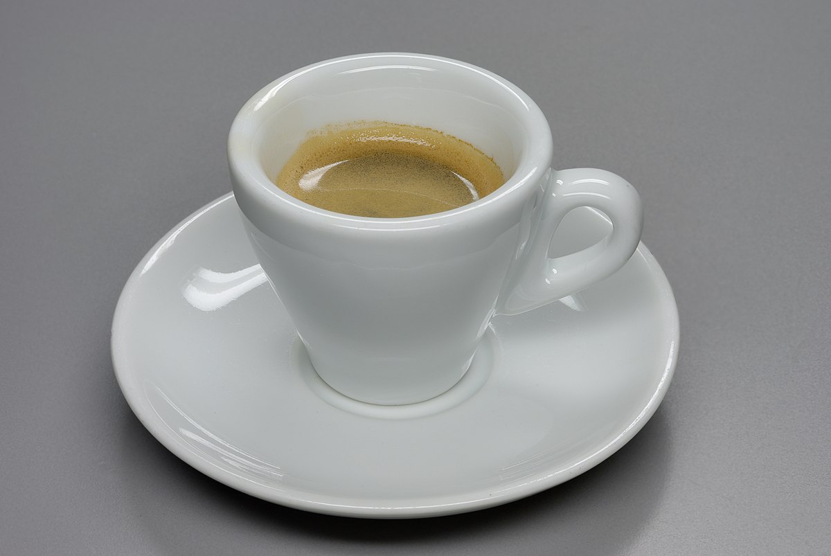 tazze da caffè espresso sotto una macchina da caffè espresso