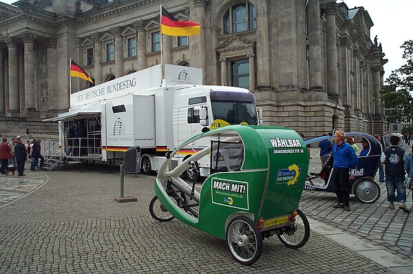 A cycle rickshaw (velotaxi) in front of the German Bundestag in Berlin with the Alliance 90/The Greens livery for the 2005 federal election