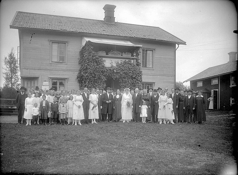 File:Gruppfoto framför hus med brudparet i mitten, från början av 1900-talet. Lima, Dalarna - Nordiska Museet - NMA.0051086.jpg