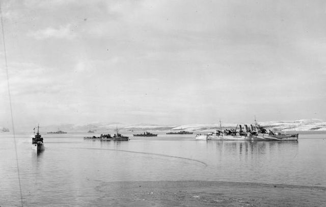 Norfolk with destroyers and merchant ships in a Russian inlet whilst on northern convoy duty. Photograph taken from Scylla