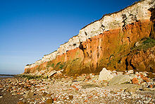 The stratified Carstone (orange),[10] red chalk limestone and white chalk cliffs on the beach at Old Hunstanton.