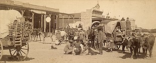 Plate photograph of a train of immigrants passing through San Angelo in 1885