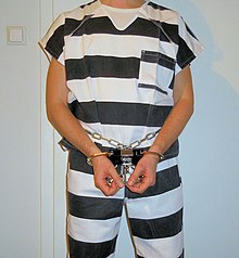 Inmate in striped prison uniform and restraints Inmate uniform (striped).jpg