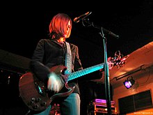 Cacing mata-pandangan Vagina wanita dengan menengah-panjang rambut brunette bermain gitar