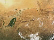 The great bend of the Niger River, seen from space, creates a green arc through the brown of the Sahel and Savanna. The green mass on the left is the Inner Niger Delta, and on the far left are tributaries of the Senegal River. Mali.A2001291.1045.250m.jpg