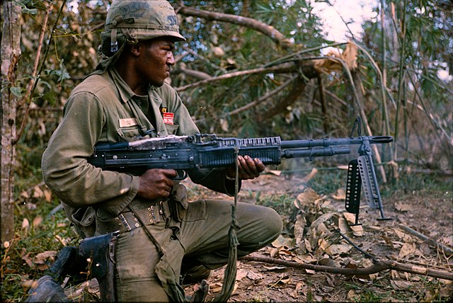 A United States Army soldier laying automatic suppressive fire with an M60 machine gun during the Vietnam War