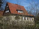 Residential house with outbuildings, wall and brick paving