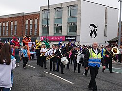 The Humberside Police Band and some stilt walkers - as well as a random security guard - lead the 2022 Pride in Hull parade.