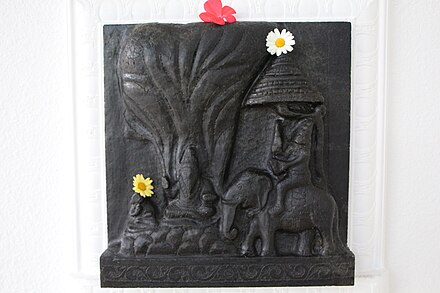Stone carving of Sage Ribhu instructing Nidagha on the wall of Sri Sadisvara Mandiram[2] in the SAT Temple