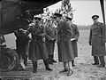 Oficiri britanskog RAF-a promatraju avion u Francuskoj, odjeveni u šinjele.