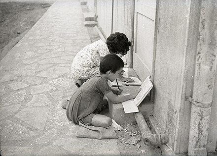 Children preparing homework on the street, Tel Aviv, 1954