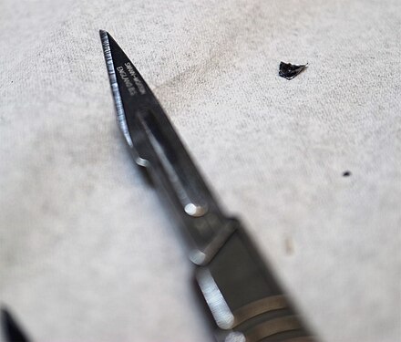 "Tip of the Blade" - Steel scalpel blade manufactured by Swann Morton. Shallow DoF, focused on the tip.