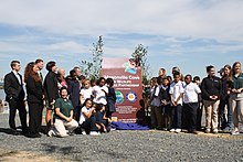 Students from Curtis Bay Elementary School unveil the Masonville Cove Urban Wildlife Refuge Partnership sign along with partners. Unveiling the Masonville designation sign (9953288823).jpg