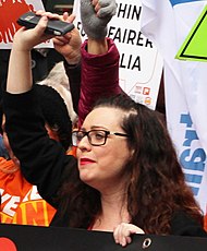Van Badham raising one arm at a Melbourne protest