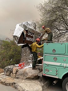 Firefighters wrap Sequoia National Park's historic entrance sign with protective foil Wrapping Historic Entrance Sign (a224b015-32d1-4fdb-81fe-3a161197c6d6).jpg