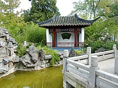 Gartenpavillon mit Wasserfall und Baumbepflanzung