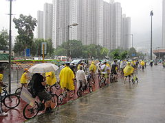 為反對擴建屯門堆填區，人民力量支持者與屯門街坊冒雨踏單車抗議。2013年7月7日。