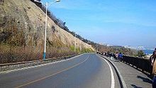 Binhai Road is the main route for Dalian International Walking Festival. View of mountain on one side and sea on the other makes it a popular exercise destination for local people. Bin Hai Zhong Lu Yue 5000Mi (retouched).jpg