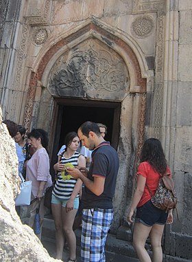 Cultural tourism: tourists outside a Geghard monastery in Armenia, 2015