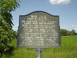 Mob Trial and Execution, an Illinois historical marker near the mob lynching site where the Banditti "prairie pirates", father and son John and William Driscoll of the Driscoll gang, were tried by an illegal Regulator court of 500 concerned citizens for murder and shot to death by a firing squad of 111 men Banditti Sign, IL 05.JPG