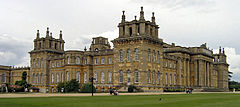 Екстериор на голям английски бароков дворец, ограден от тревни площи