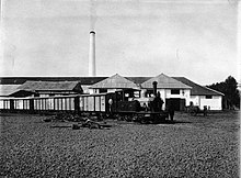 Steam train in front of the Kalibagor sugar refinery COLLECTIE TROPENMUSEUM De stoomtram met locomotief staat klaar voor het suikertransport op de suikeronderneming Kalibagor. Op de voorgrond ligt een deel van het oud ijzer klaar om opgeladen te worden. TMnr.jpg