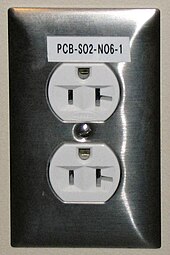 5-20R T-slot receptacle mounted with the hole for the ground pin at the top. The neutral connection is the wider T-shaped slot on the right. Electrical outlet with label.jpg