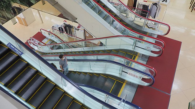 Crisscross spiral escalators