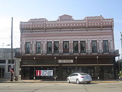 Two-story brick commercial buildings with an elaborate faced including a cast-iron gallery.