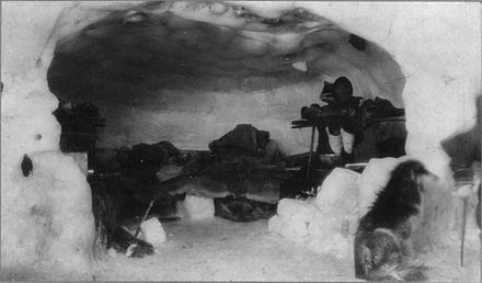 An Inuk inside an igloo, early-20th century.