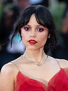 Jenna Ortega posing in a red outfit at the 81st Venice Film Festival