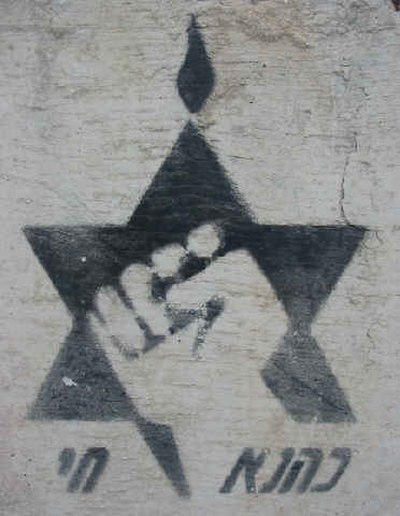 Kach logo spraypainted on a cement block reading "Kahane Chai"