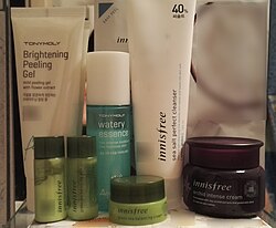 Various Korean cosmetics products (peeling gel, essence, cleanser, toner, lotion and two types of creams) on a bathroom shelf Korean cosmetics on a shelf.jpg