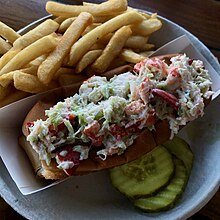 A lobster salad roll served with fries and pickles at a restaurant in Massachusetts. Lobster salad roll.jpg