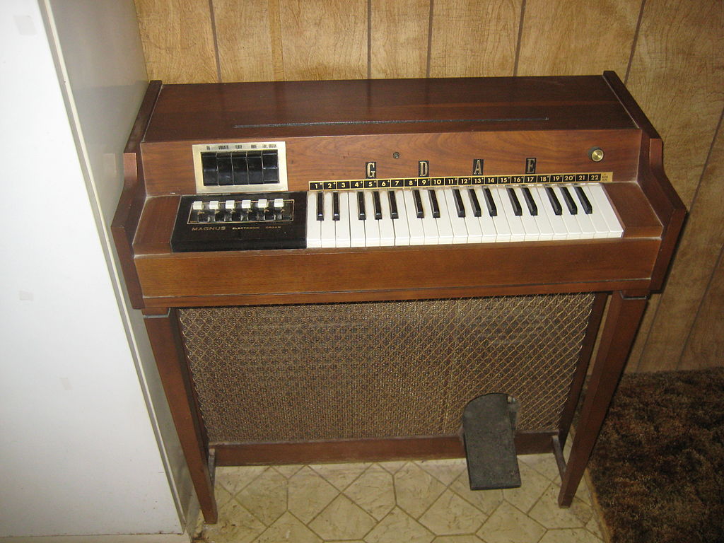 https://upload.wikimedia.org/wikipedia/commons/thumb/4/42/Magnus_electric_chord_organ_%28free_stand%2C_wood%2C_3oct%2C_6maj%2C_6min%2C_3stop%2C_vib%29.jpg/1024px-Magnus_electric_chord_organ_%28free_stand%2C_wood%2C_3oct%2C_6maj%2C_6min%2C_3stop%2C_vib%29.jpg