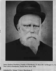 Bilde av en eldre, skjeggete mann iført en mørk hatt