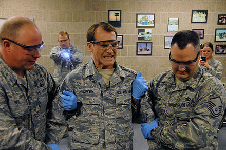 Controlled taser demonstration by the North Dakota Air National Guard. The center person is being shocked through his back while being held to prevent falling injuries.