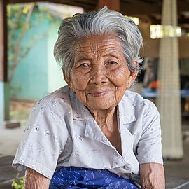 Old woman of Don Puay (Si Phan Don, Laos) with grey hair and wrinkled skin, smiling