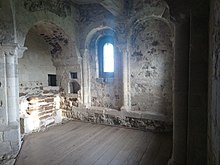 The 12th-century chapel at Orford Castle is located in the keep above the entrance to the tower. The altar is visible on the left, and when raised the portcullis abutted the wall on the right. Orford Castle chapel, September 2018.jpg