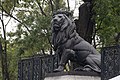 Escultura de león en el pedestal izquierdo.