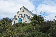 A photo of a Presbyterian church atop a lush hill