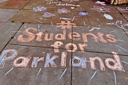 加州为遇难学生举行守夜仪式，民众在道路上刻画标记