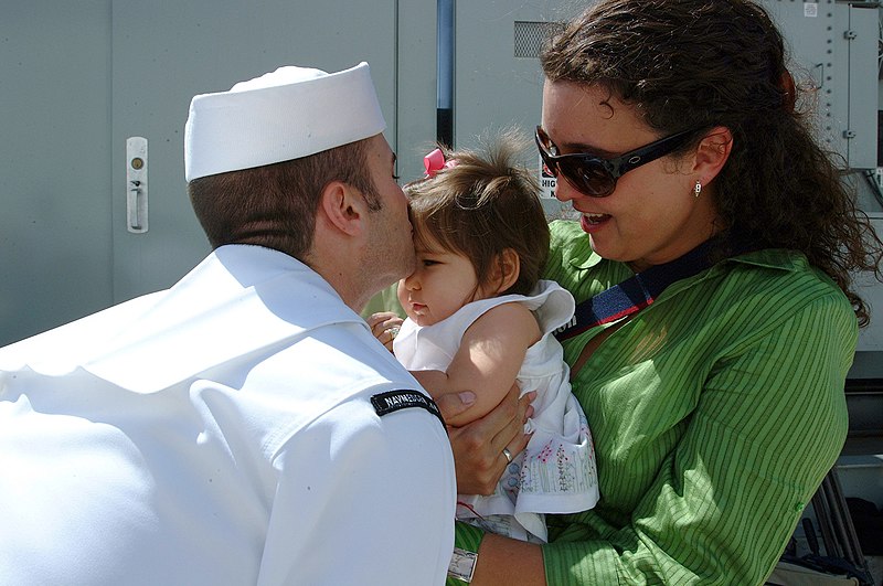 File:US Navy 050608-N-6504N-002 Journalist 1st Class Joshua Smith kisses his baby on the pier after getting off the Military Sealift Command (MSC) hospital ship USNS Mercy (T-AH 19).jpg